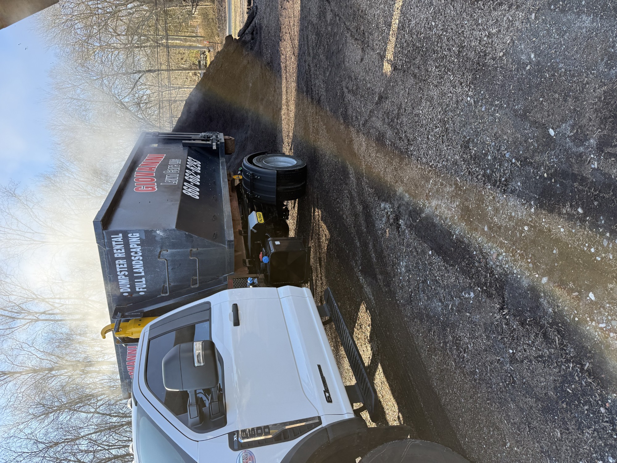 Giovanni roll-off dumpster truck delivering a container